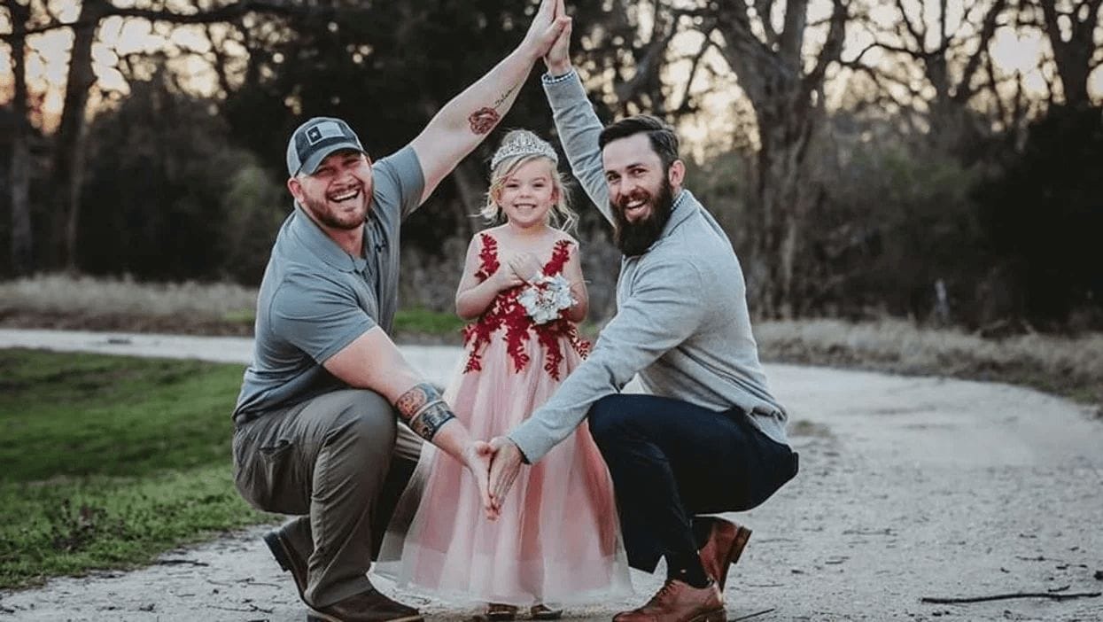 dad and stepdad posing with daughter