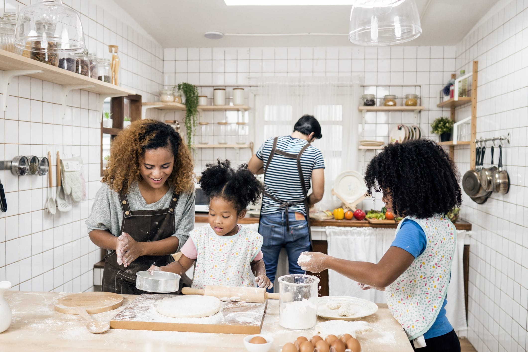 Family with two kids preparing food in kitchen - experience gifts