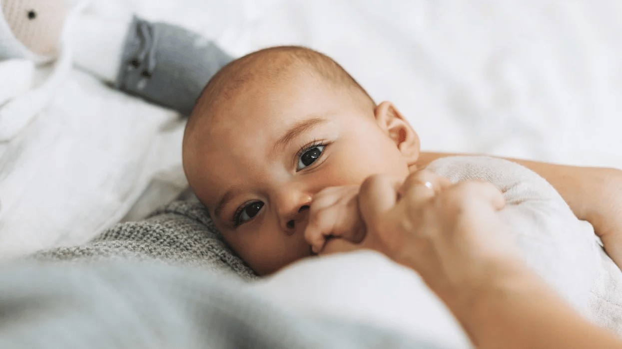 baby grabbing mom's hand - 6-month-old baby feeding schedule