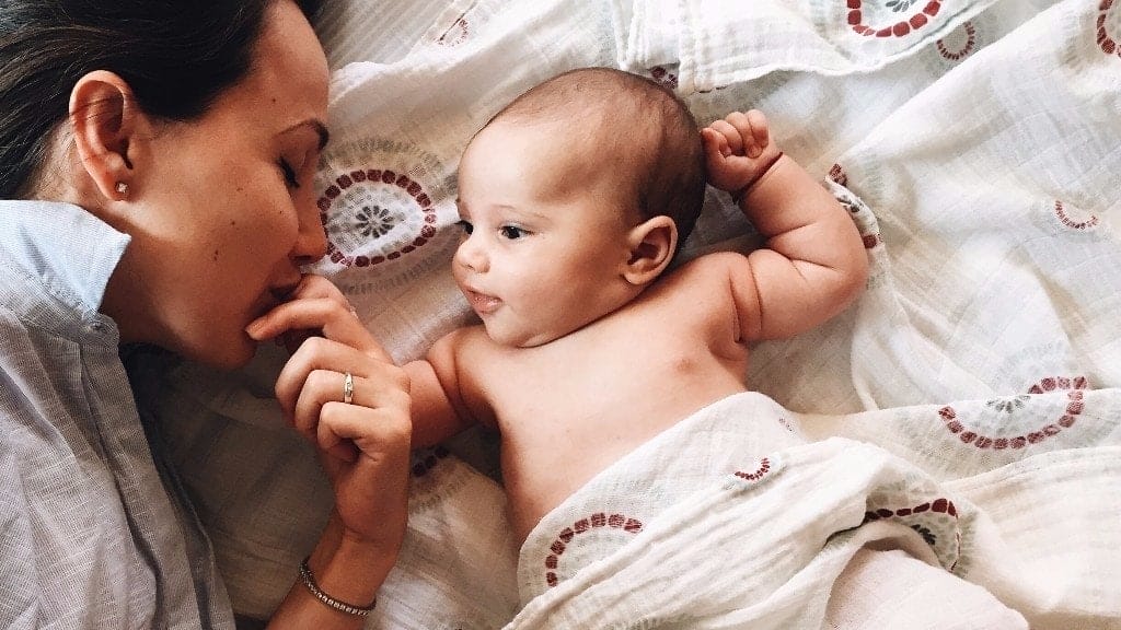 dad laying with newborn baby