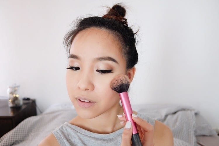 woman putting on makeup