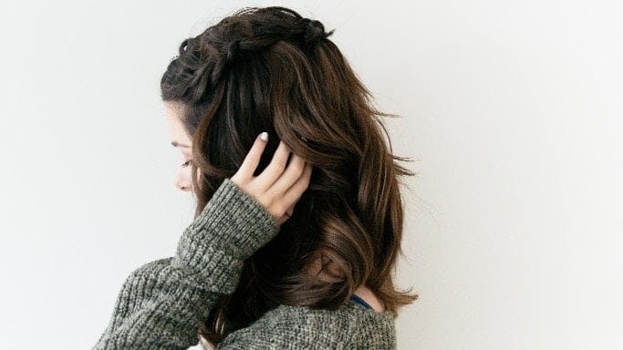 woman brushing hand against hair