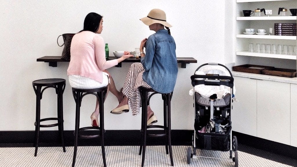 two women sitting in a cafe together