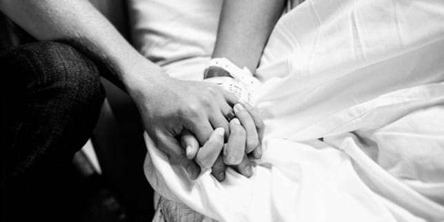 birth partner holding mom's hand as she wonders what to do for a long labor