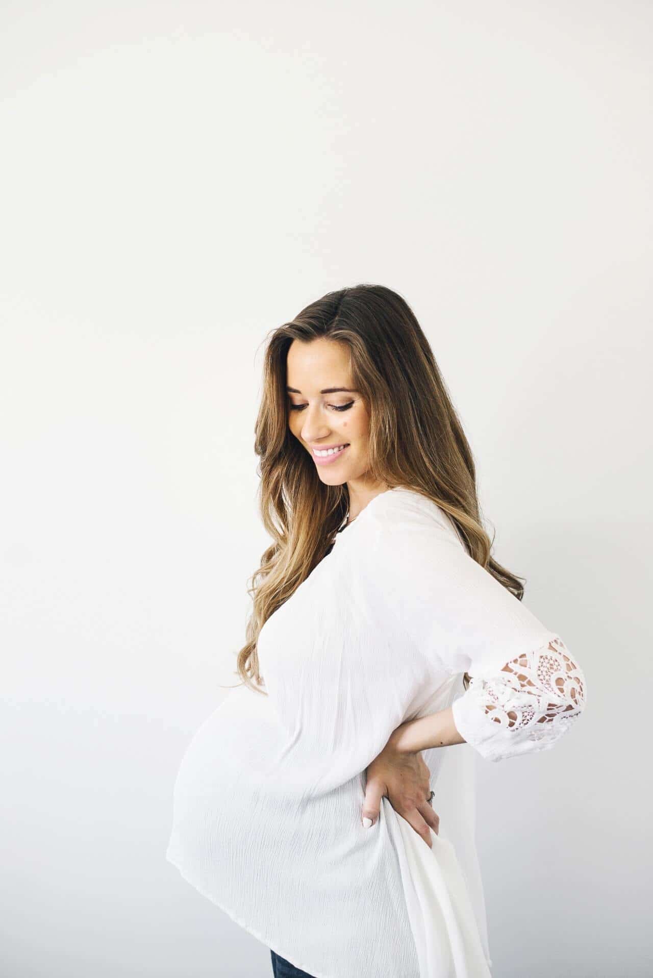 woman holding her pregnant belly as she takes steps on how to prepare for a c section