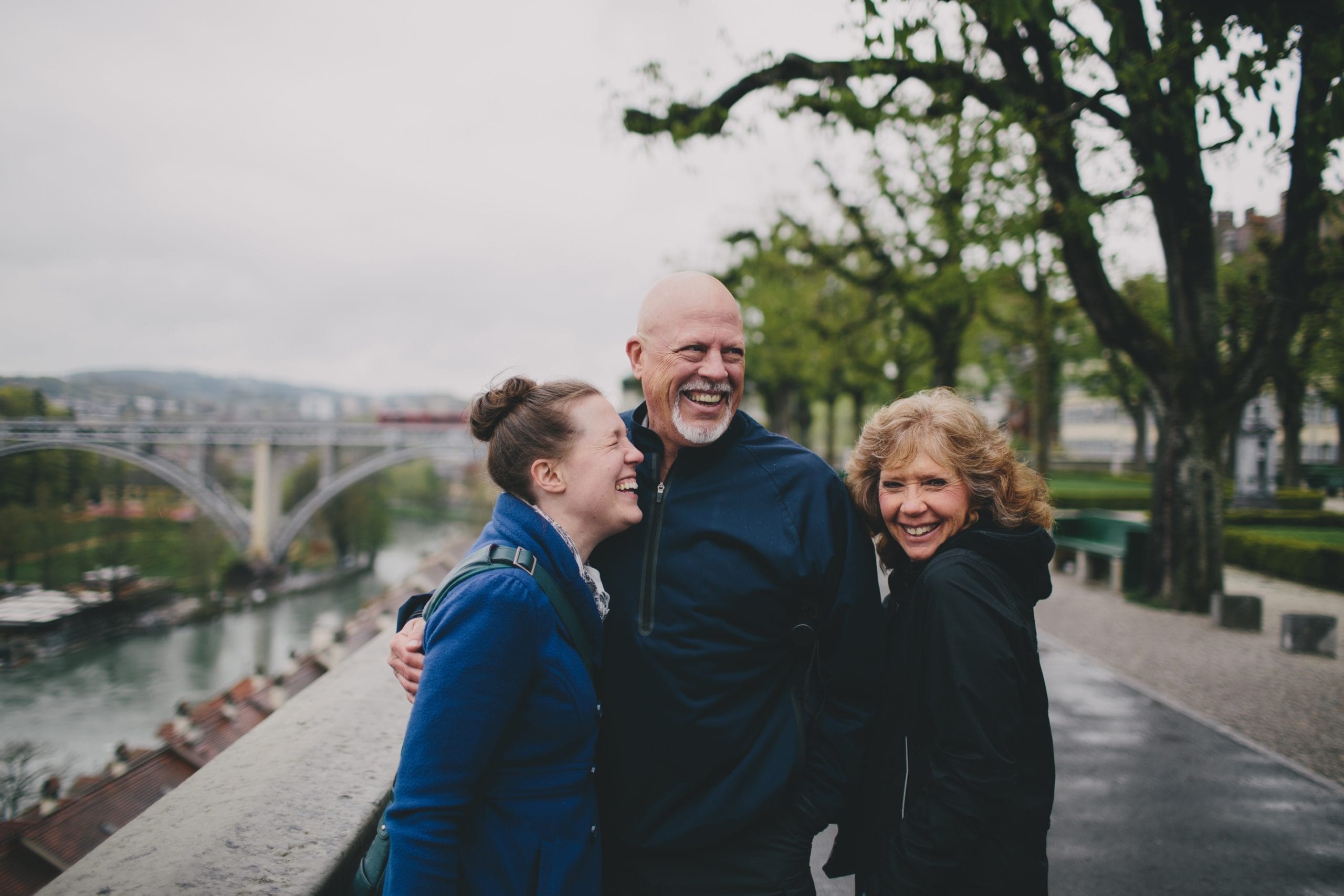 caregiving for parents: daughter stands with older parents outside