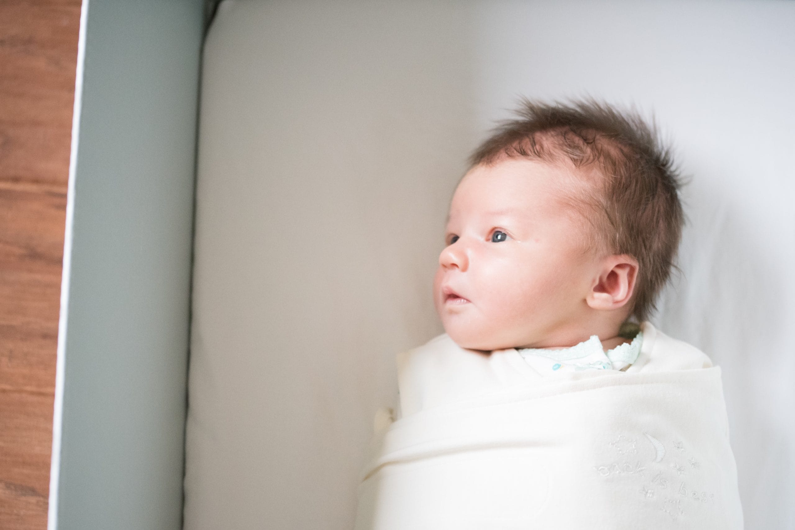 swaddled baby in a bassinet