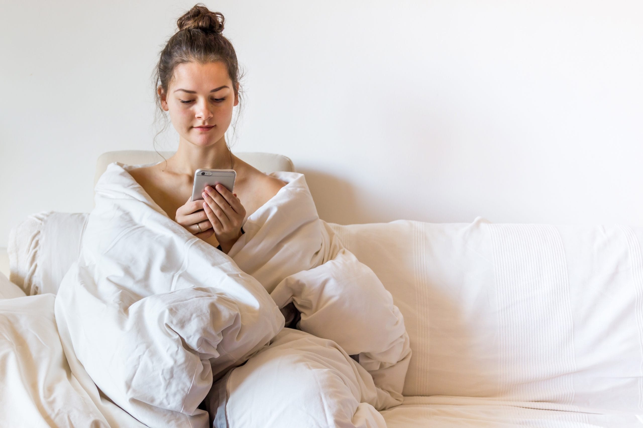 woman wearing a robe on her phone