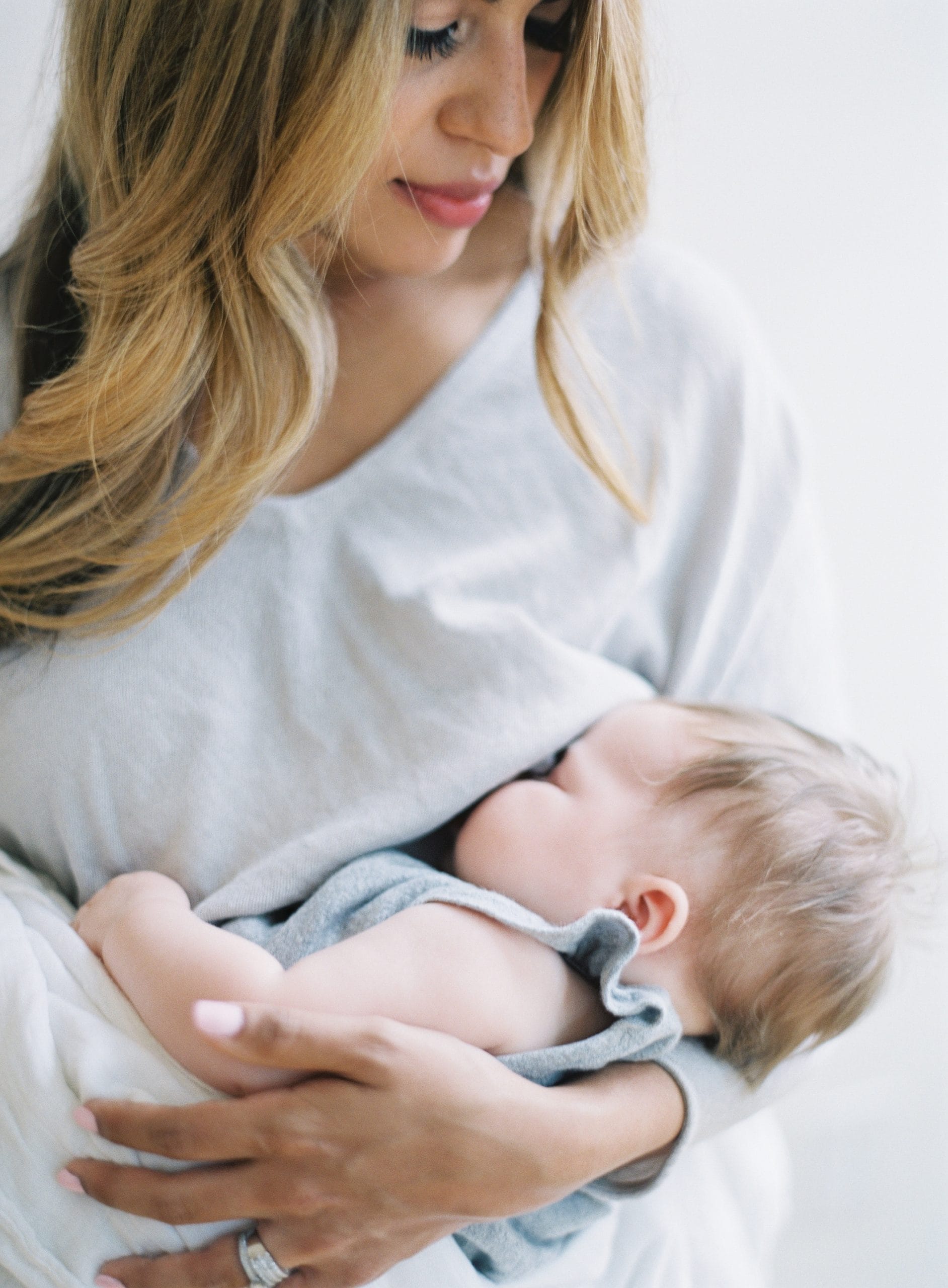 woman breastfeeding baby under her shirt