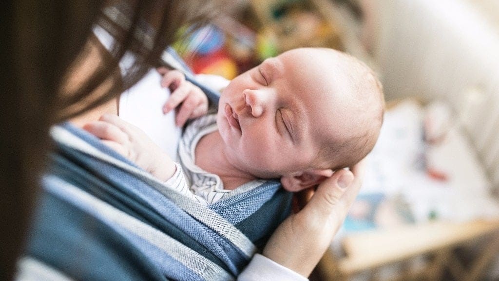 mom looking down at newborn baby-the rawness of motherhood