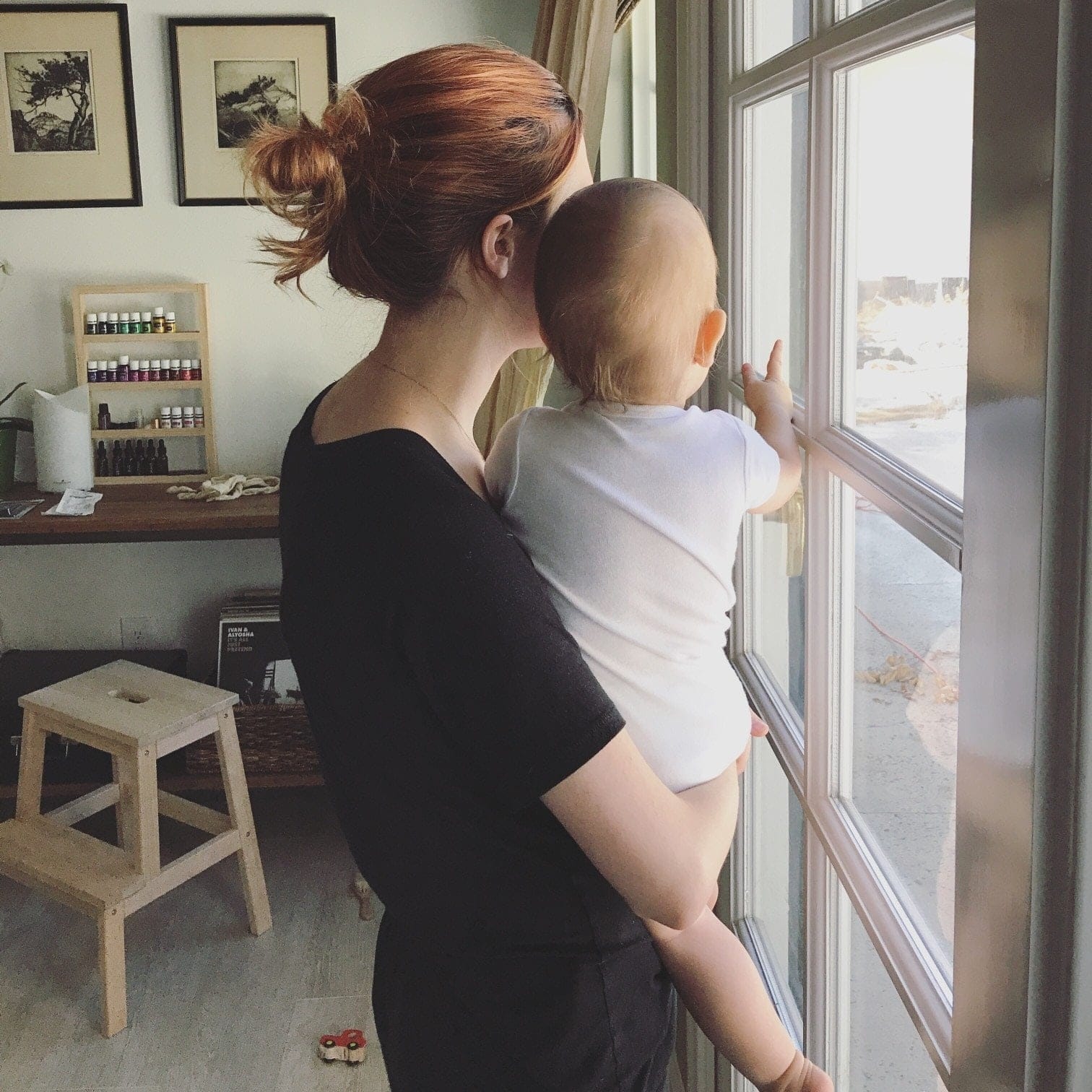 mom holding baby up to a window