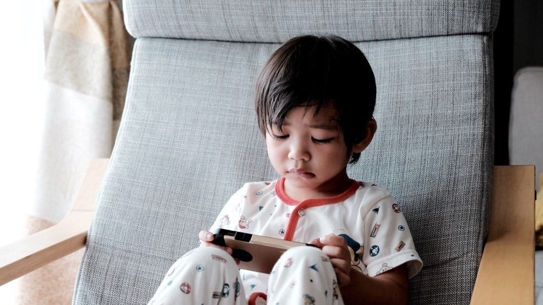 little boy playing on a phone