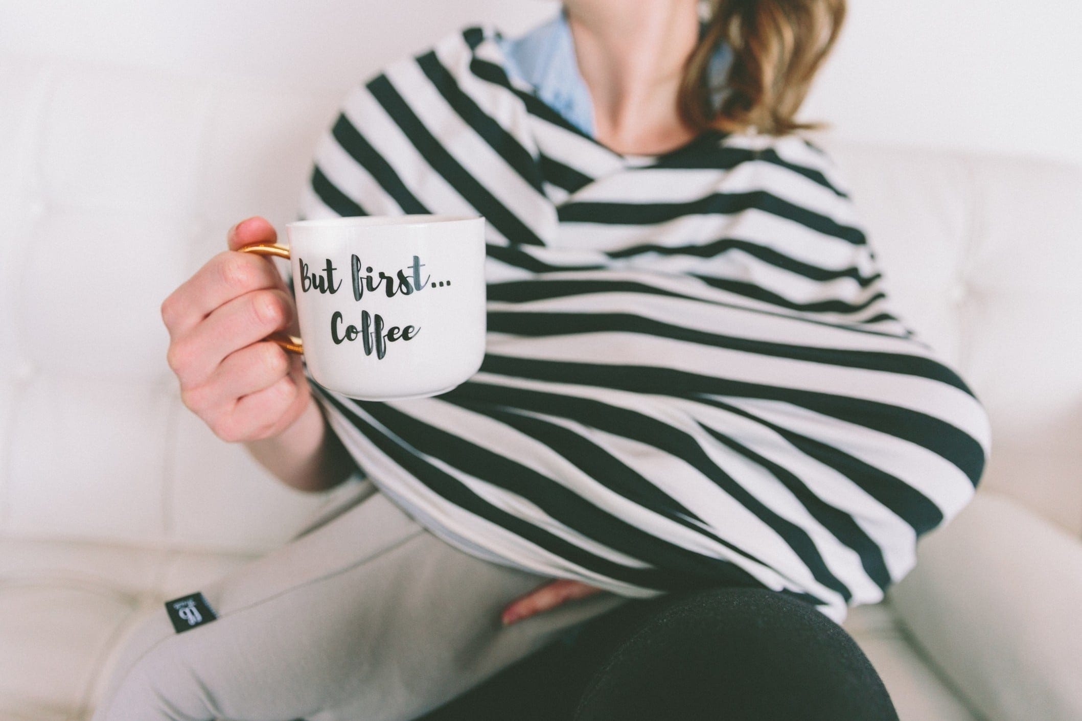 mom holding coffee mug and breastfeeding- i can't live without coffee