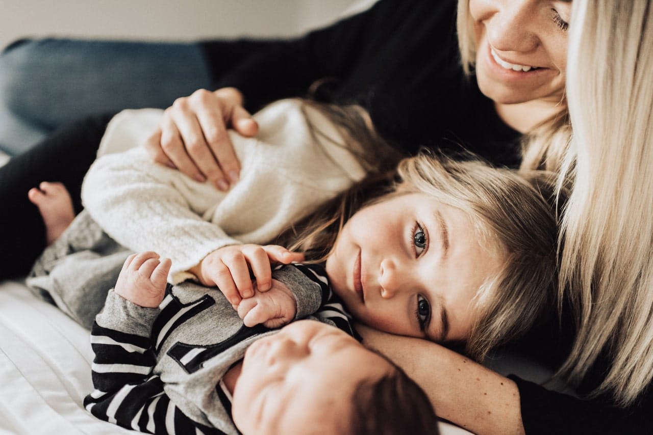 mom snuggling two kids