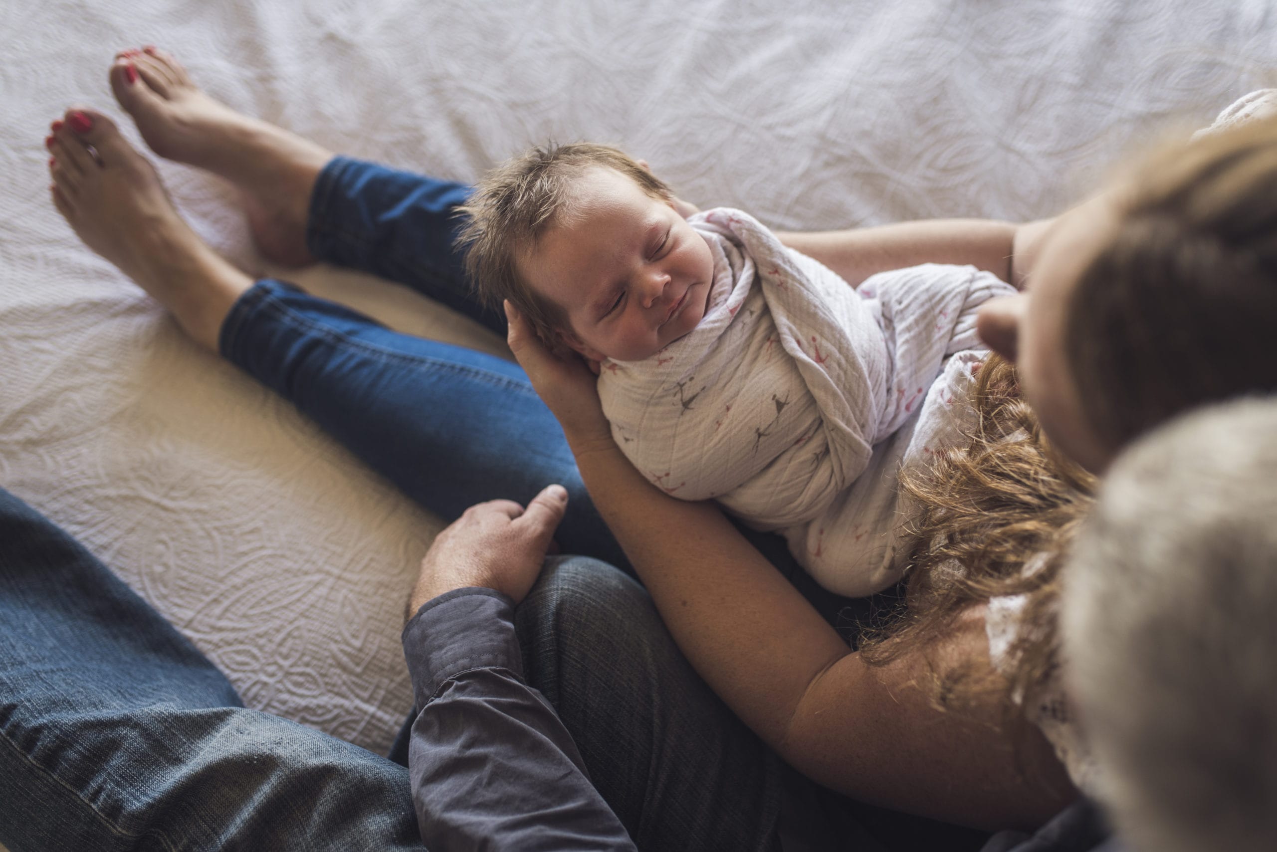 mom holding swaddled baby- hitting milestones