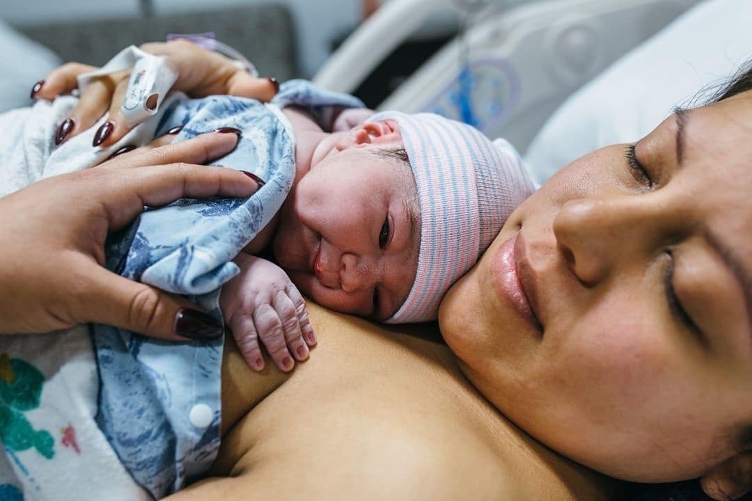 mother holding newborn on her chest, preparing for the first night home with baby