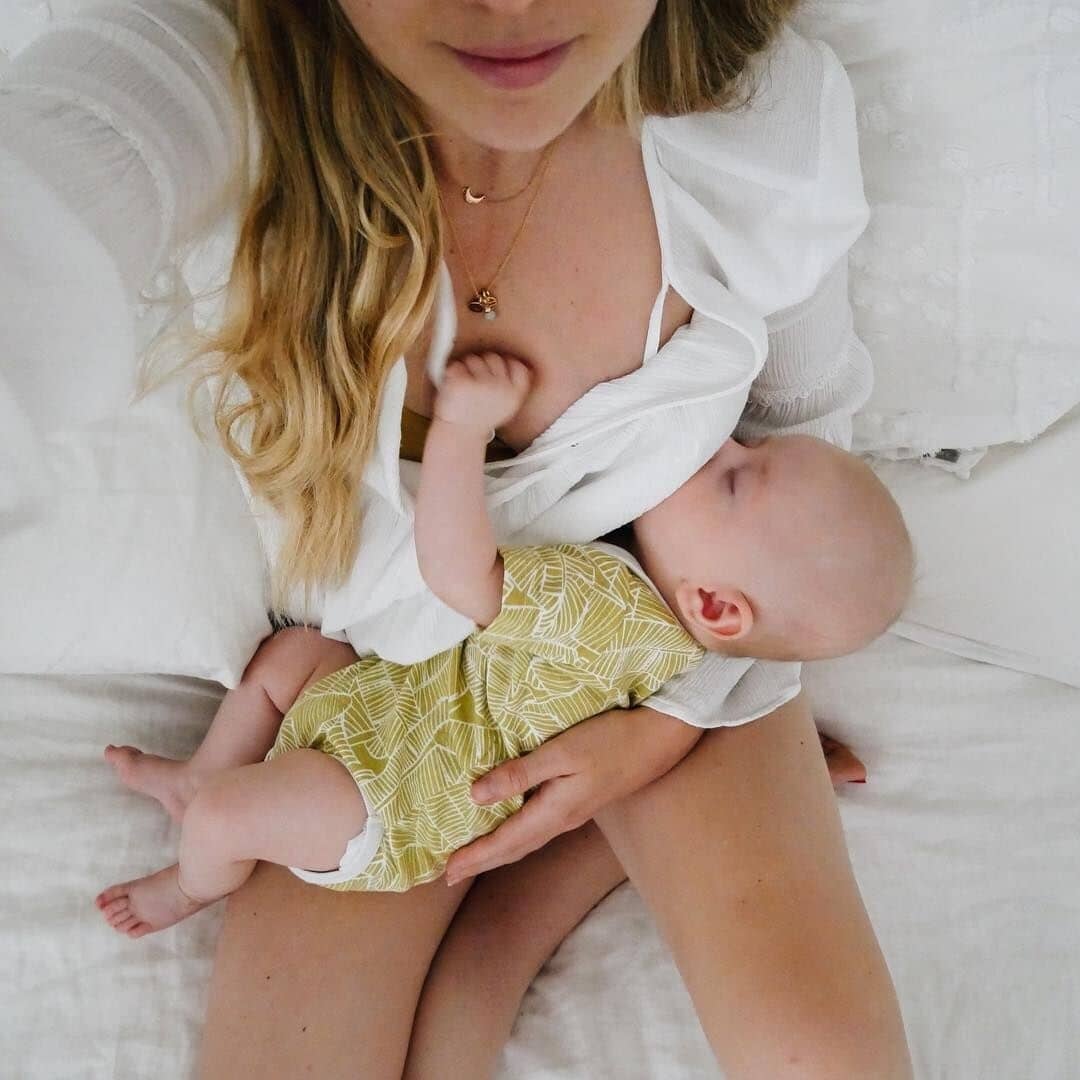 mother breastfeeding baby at home