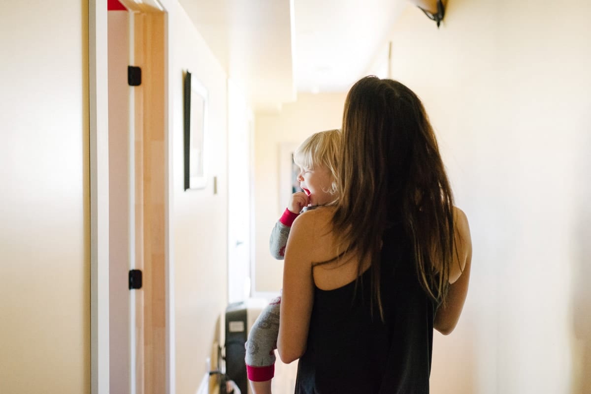 woman carrying crying toddler