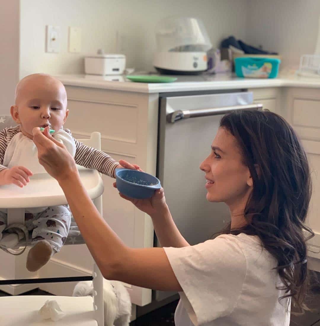 Hilaria Baldwin feeding her son in a high chair