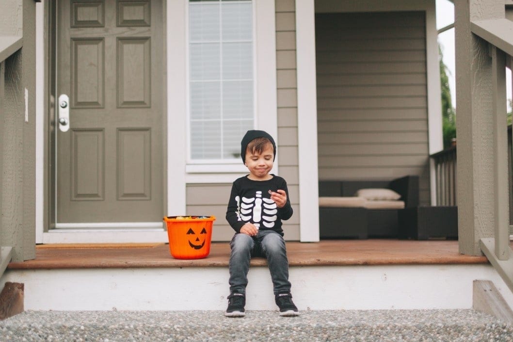 little boy dressed up for Halloween eating candy