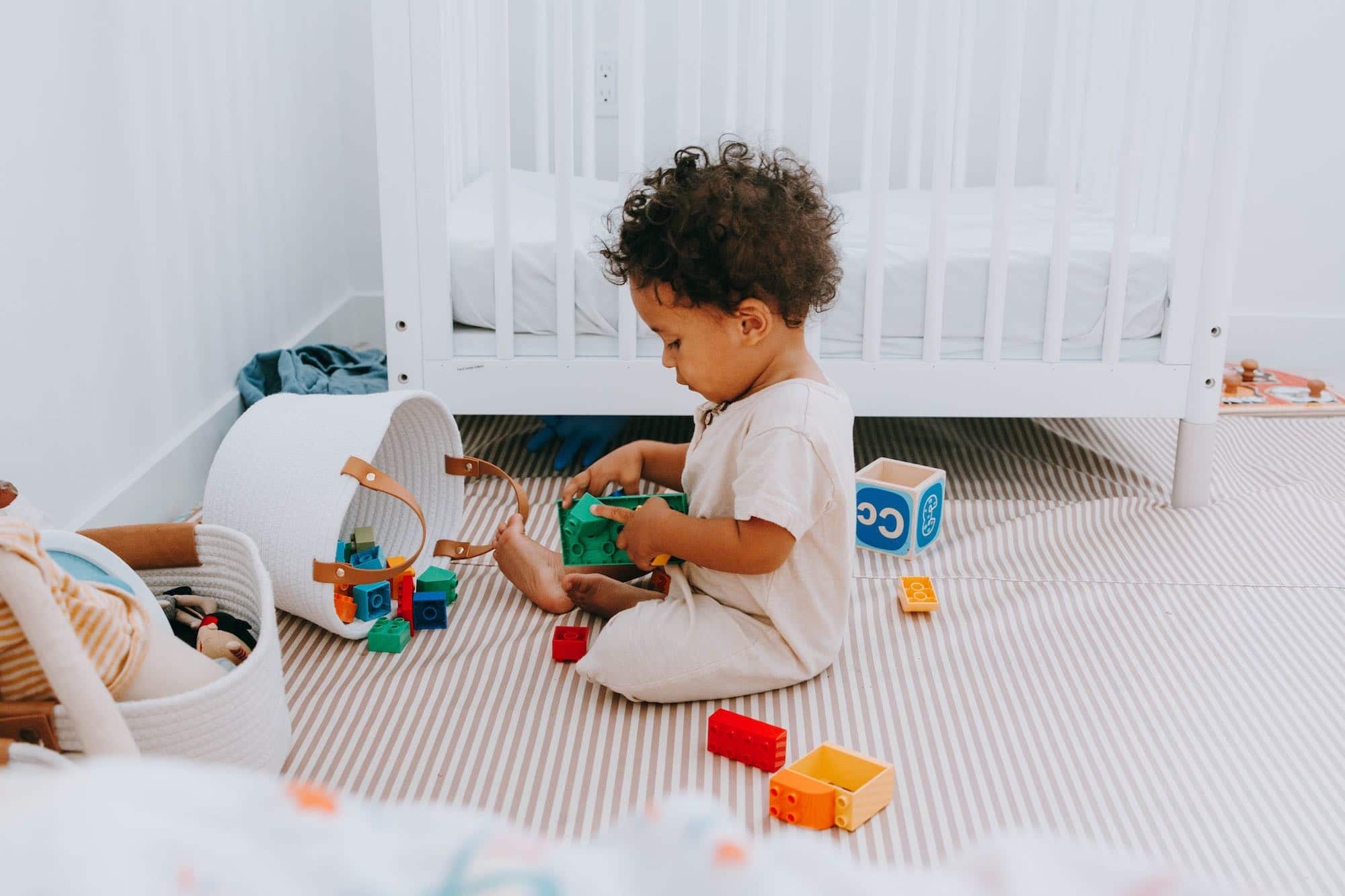 little boy playing with toys on his floor