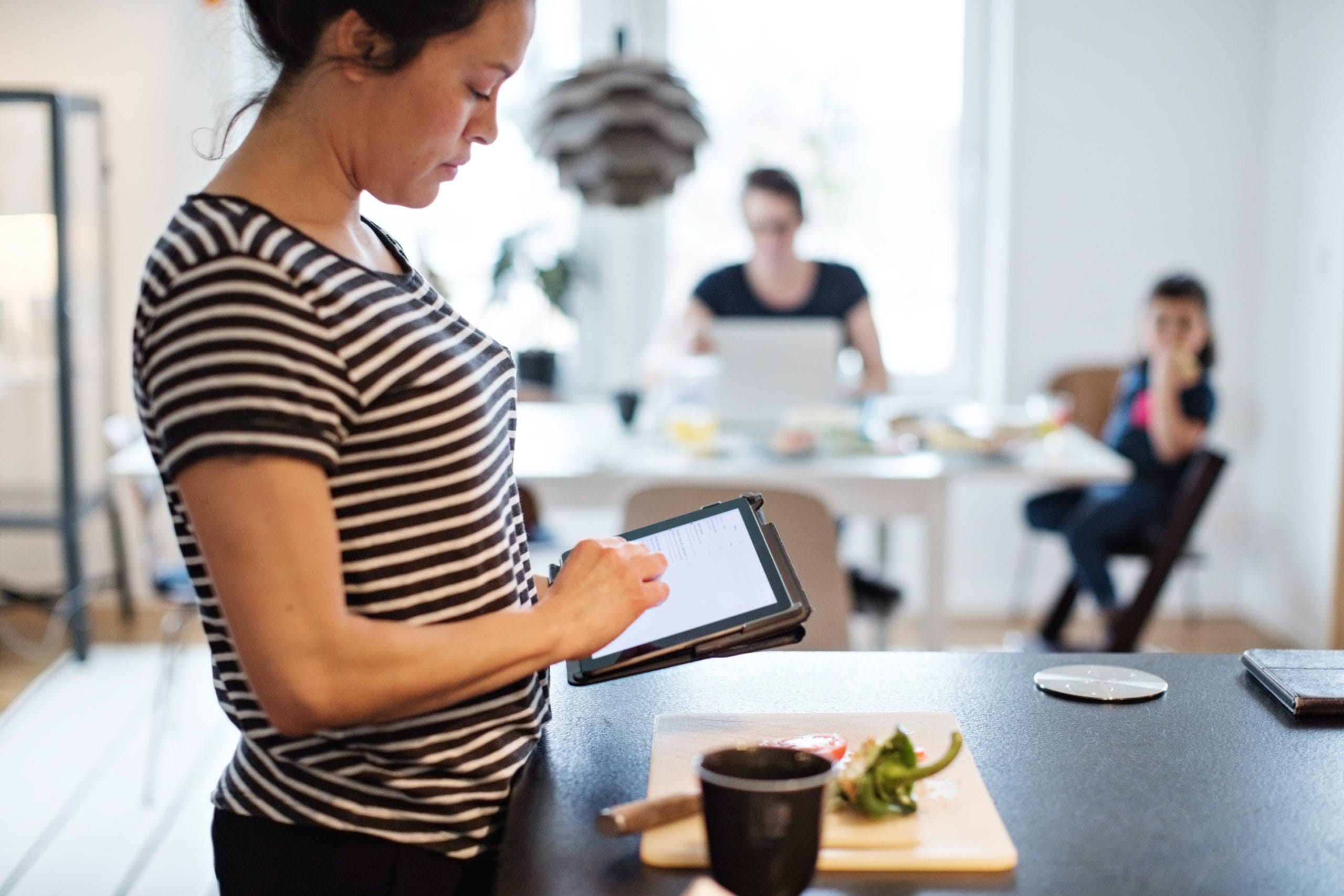 woman on a tablet making dinner