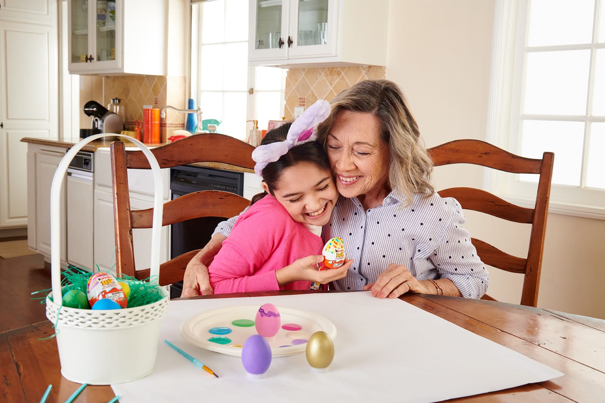 mom hugging daughter while coloring Easter eggs