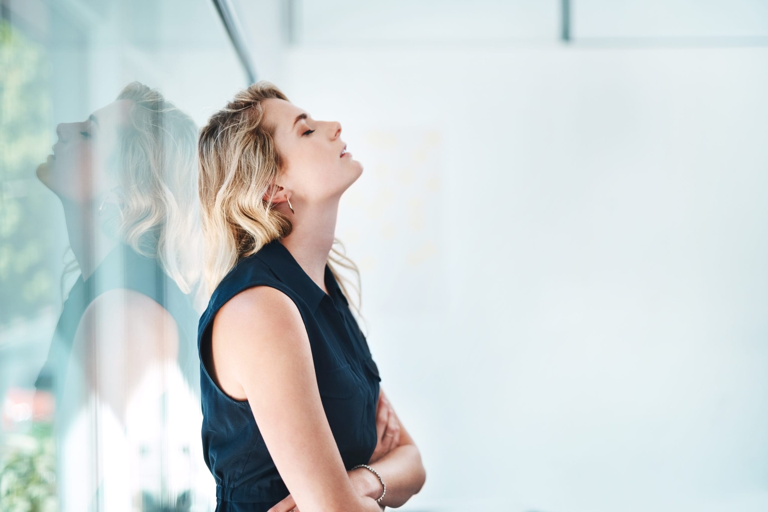 sad woman leaning against a wall