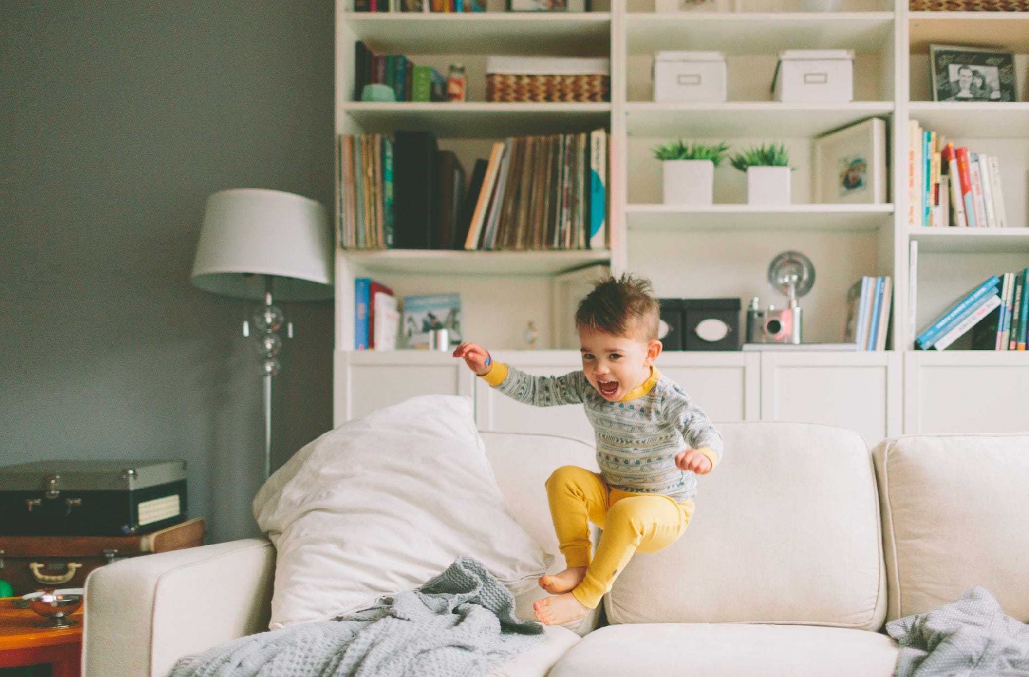 little boy jumping on the couch