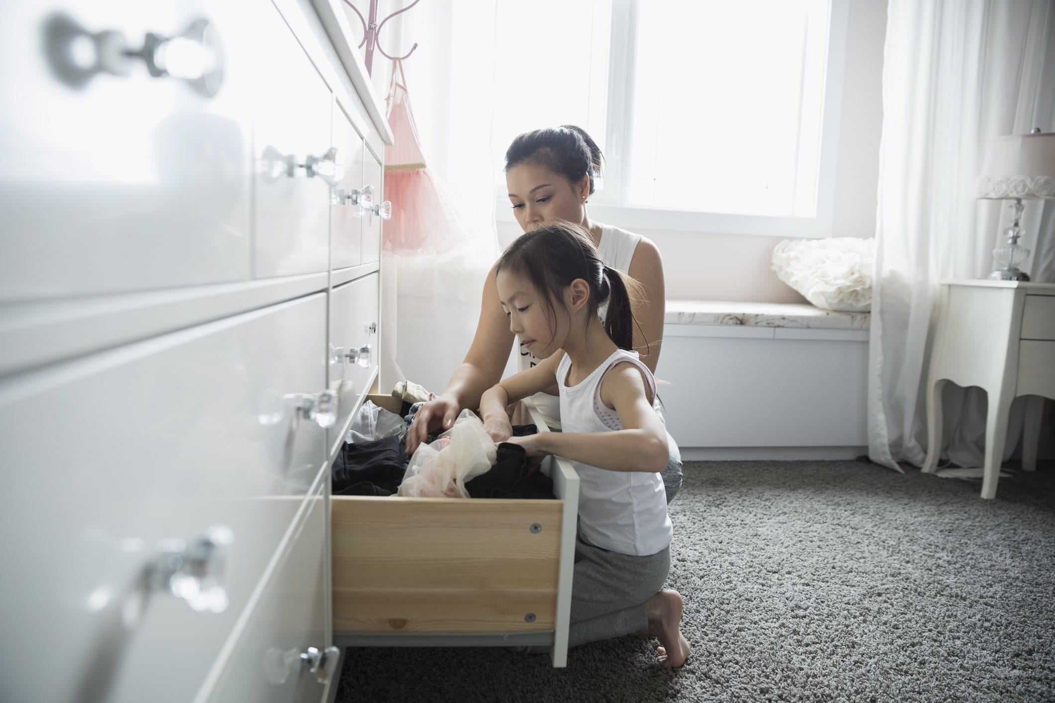 mom and daughter cleaning dresser drawers