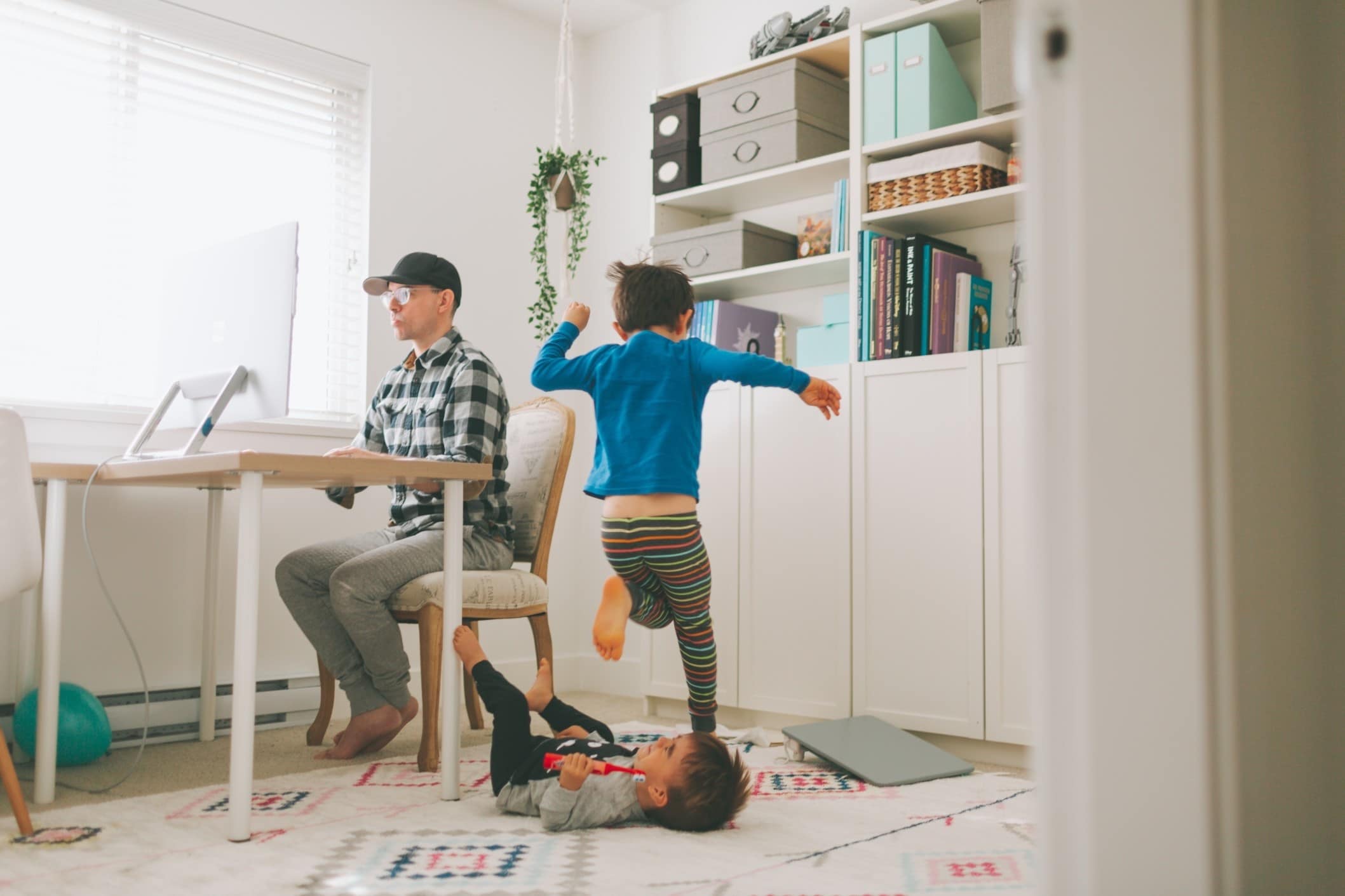 dad working while child plays behind him