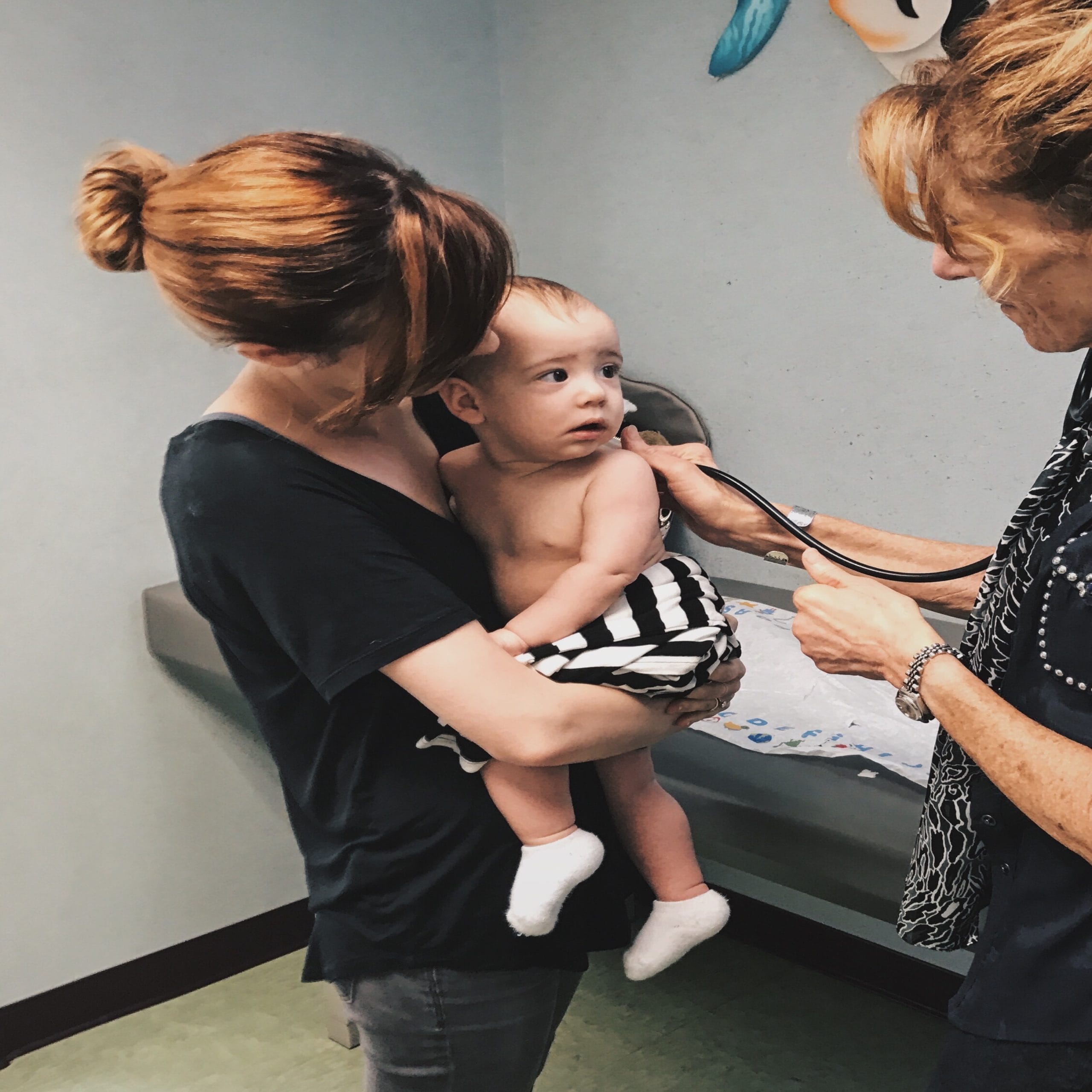 mom holding child at the pediatrician