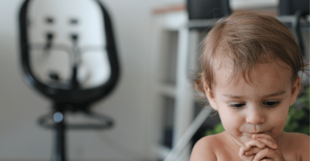 little boy eating in a high chair