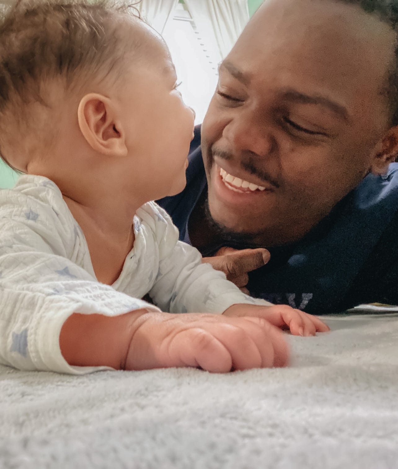 dad playing with baby on the floor