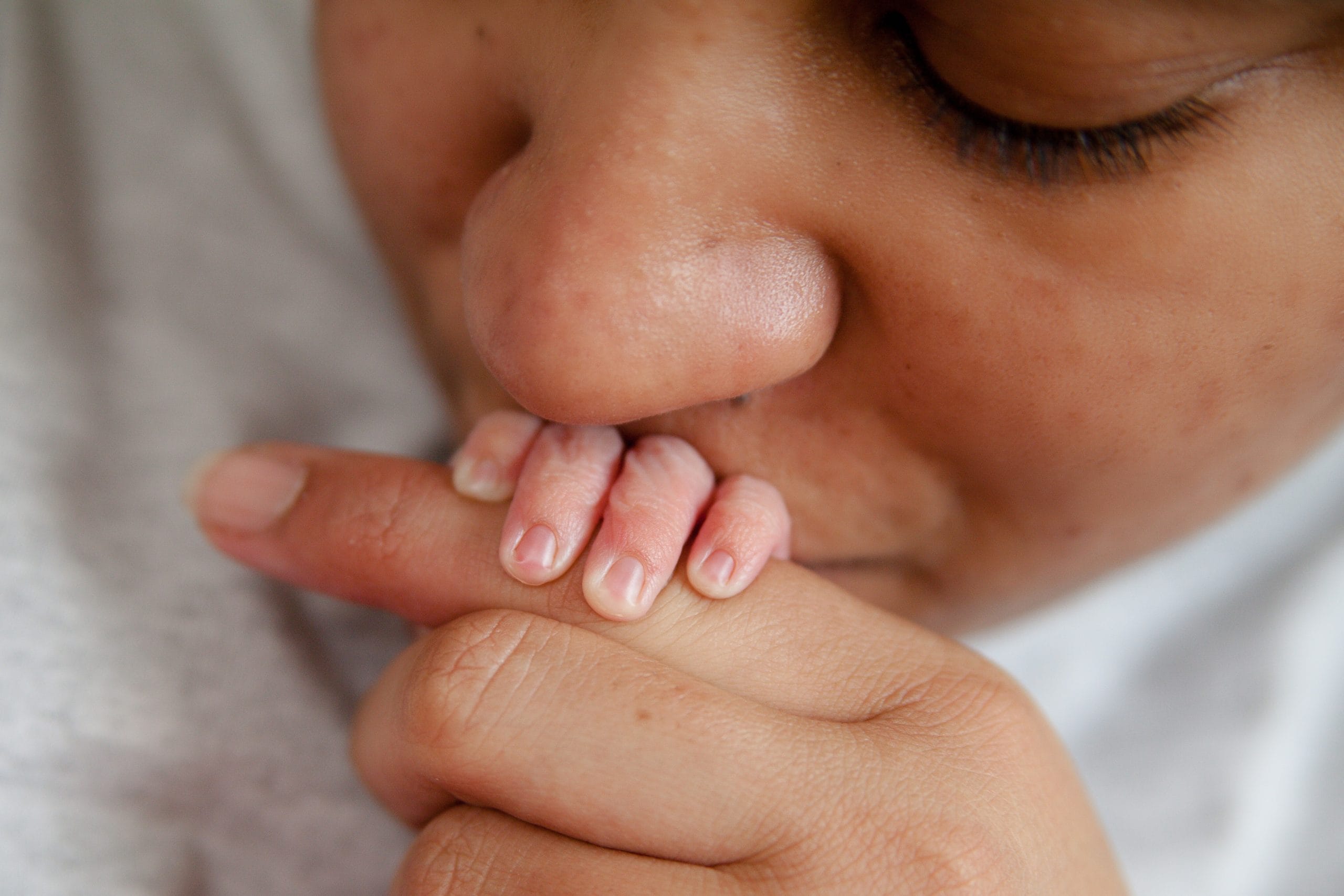 mom kissing baby hand