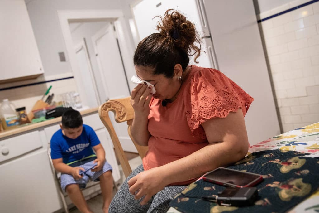 woman crying while son sits in background