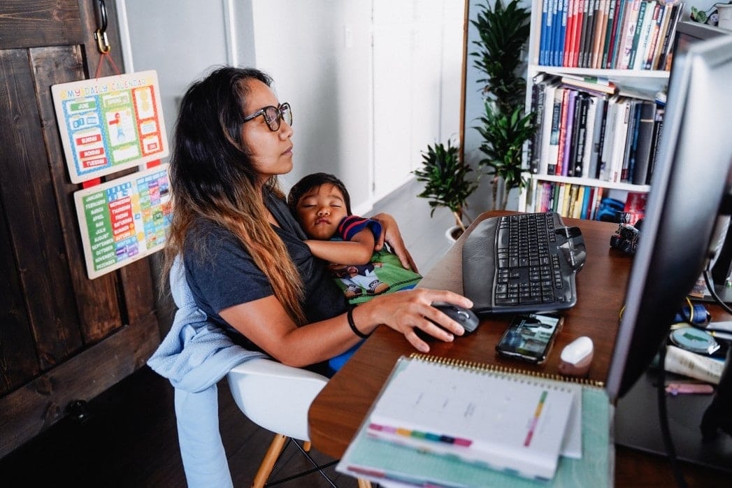 woman working while holding baby