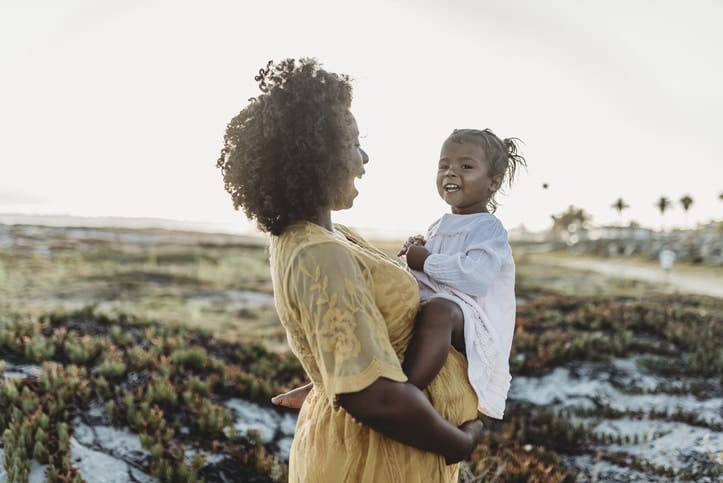 pregnant mom holding little girl