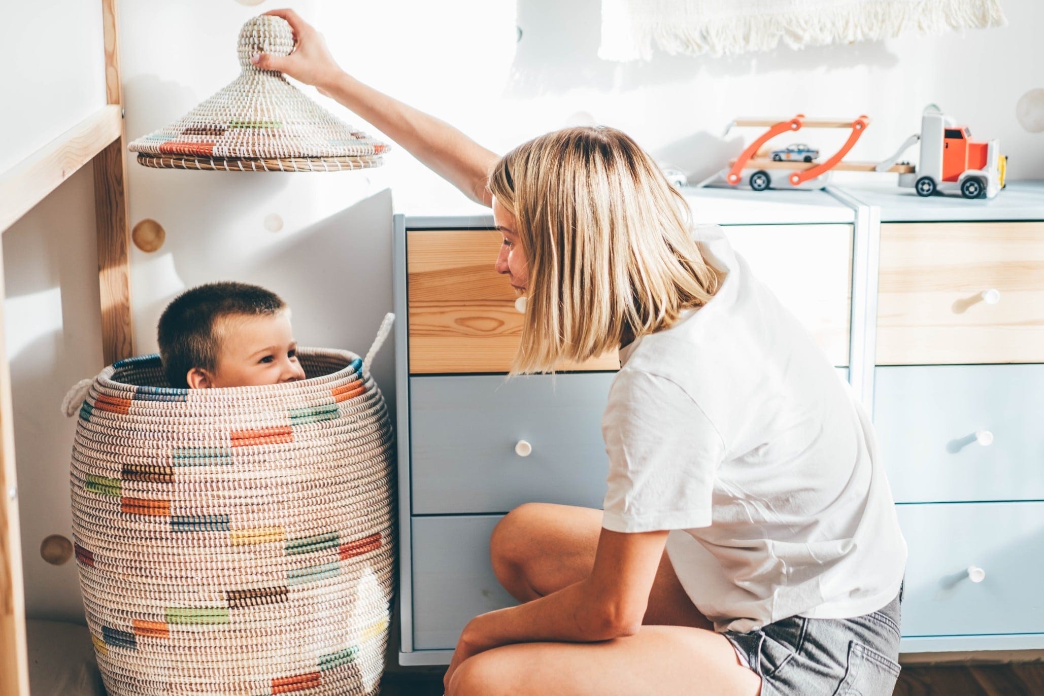 mom playing with son in a hamper