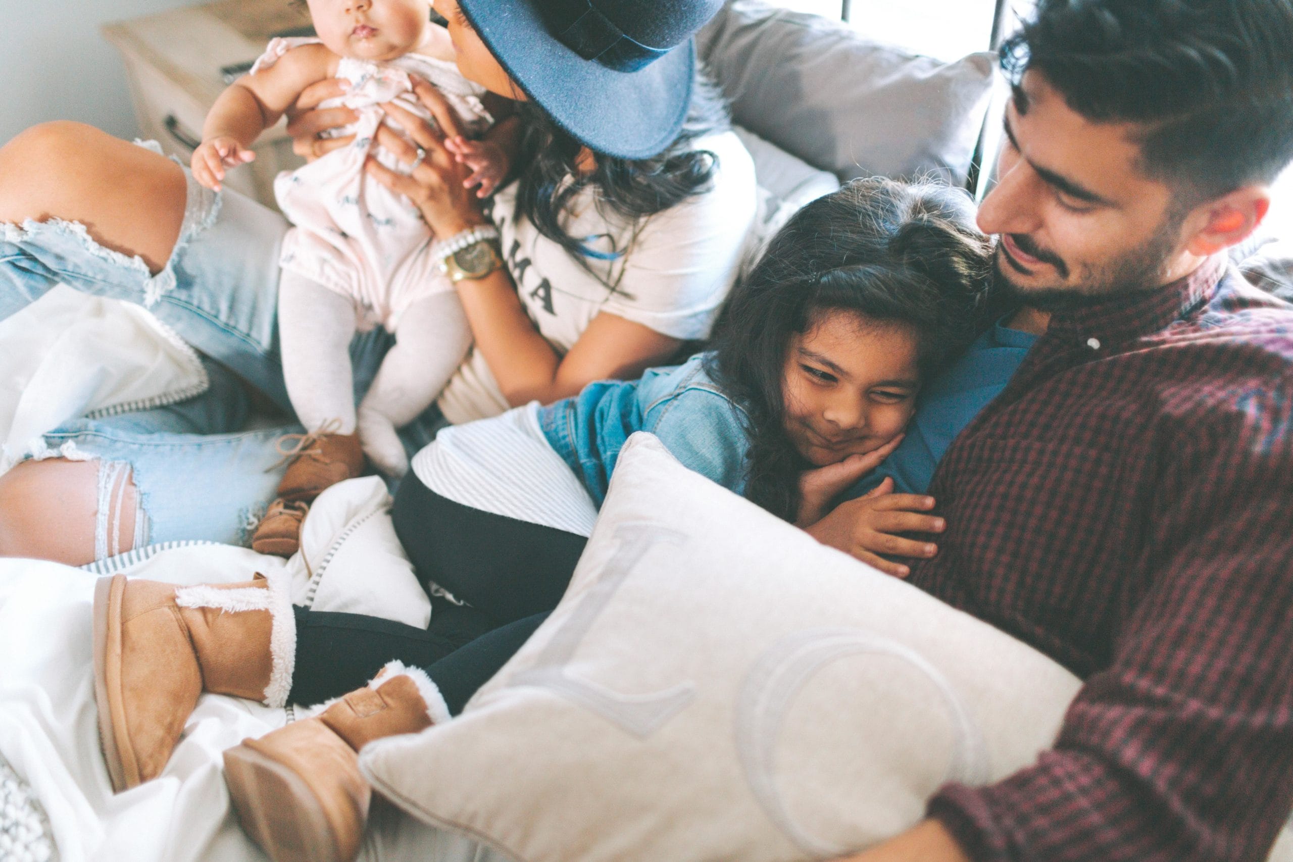 family snuggled on the couch watching tv together