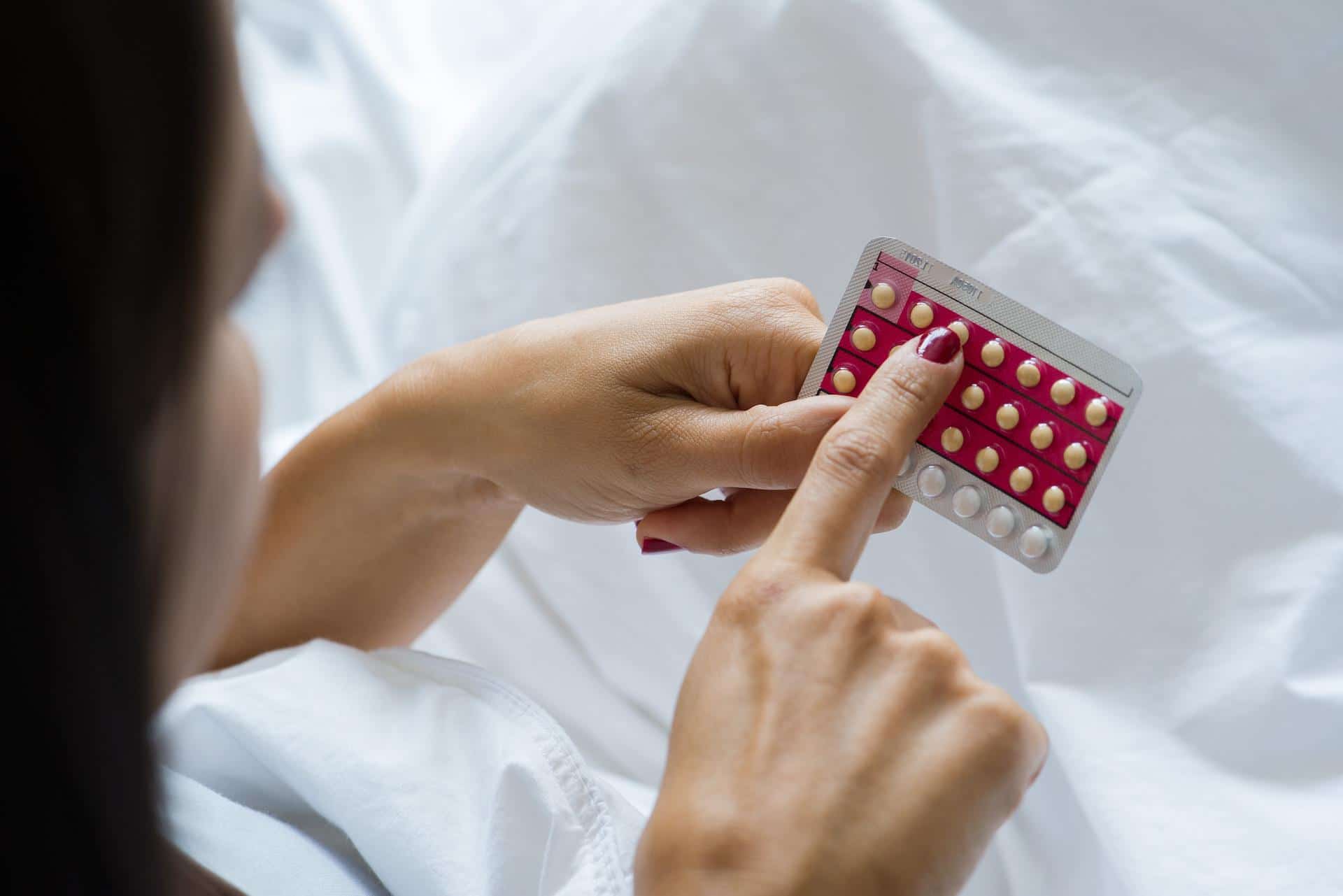 woman counting birth control pills