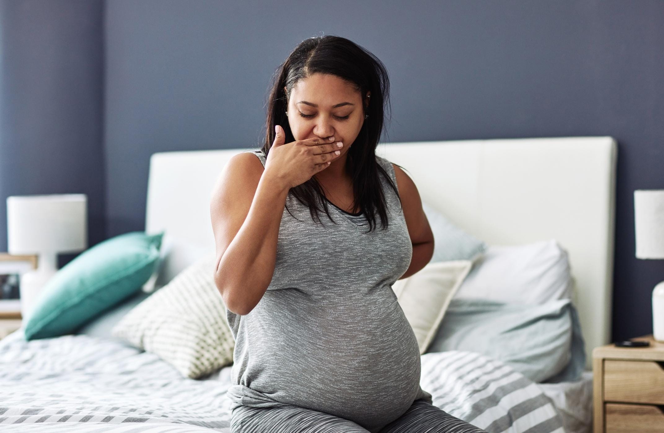 woman covering her mouth while pregnant