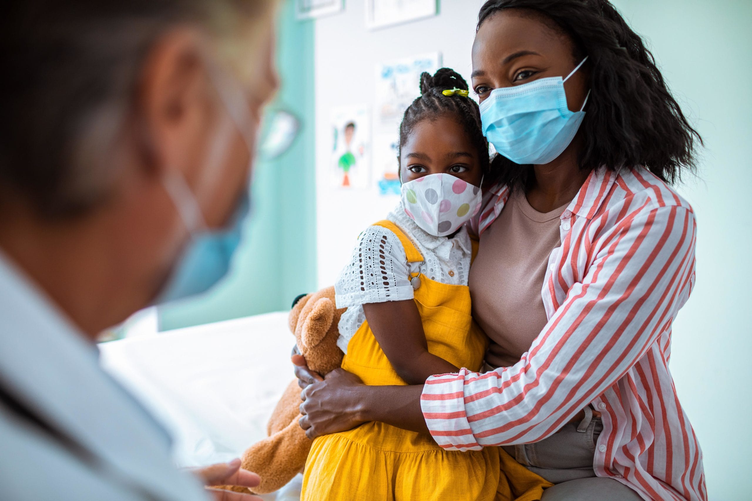 woman holding daughter in medical office