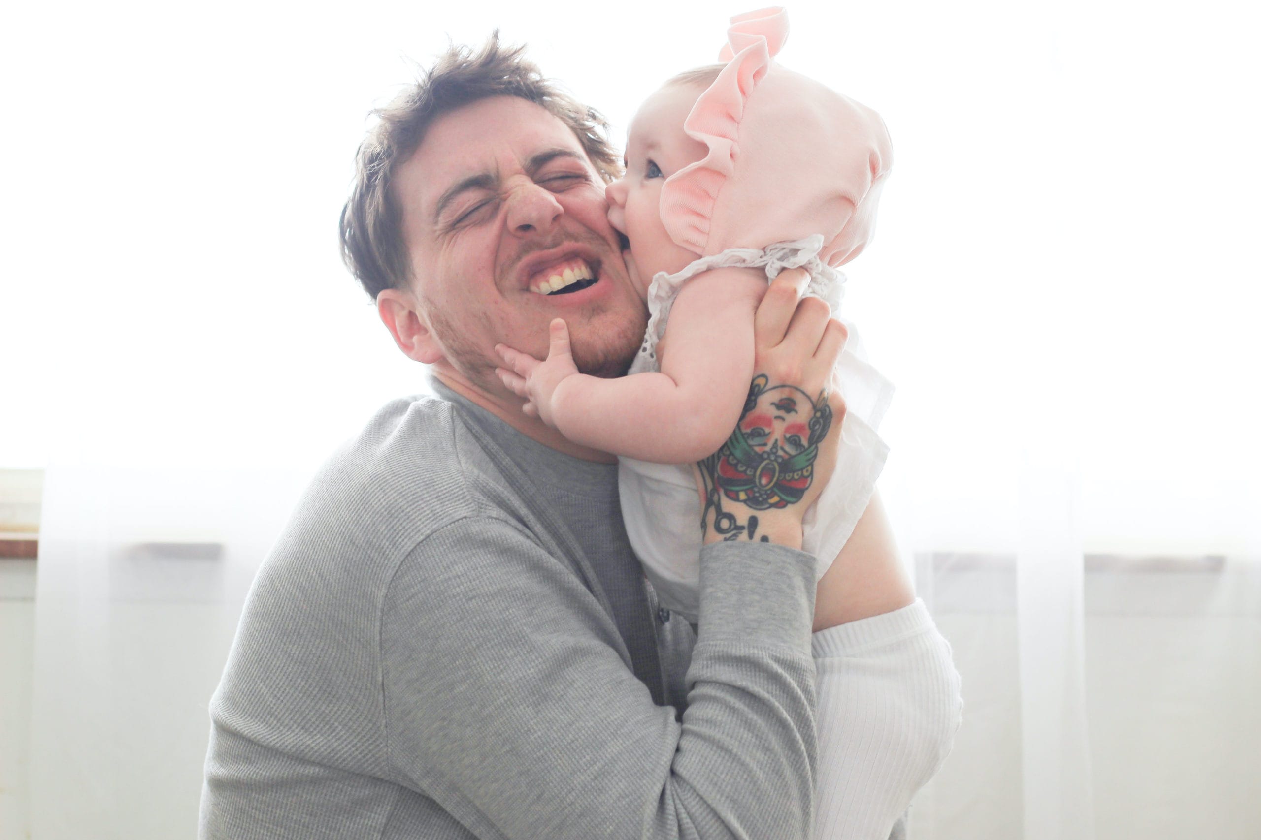 baby kissing dad on the cheek