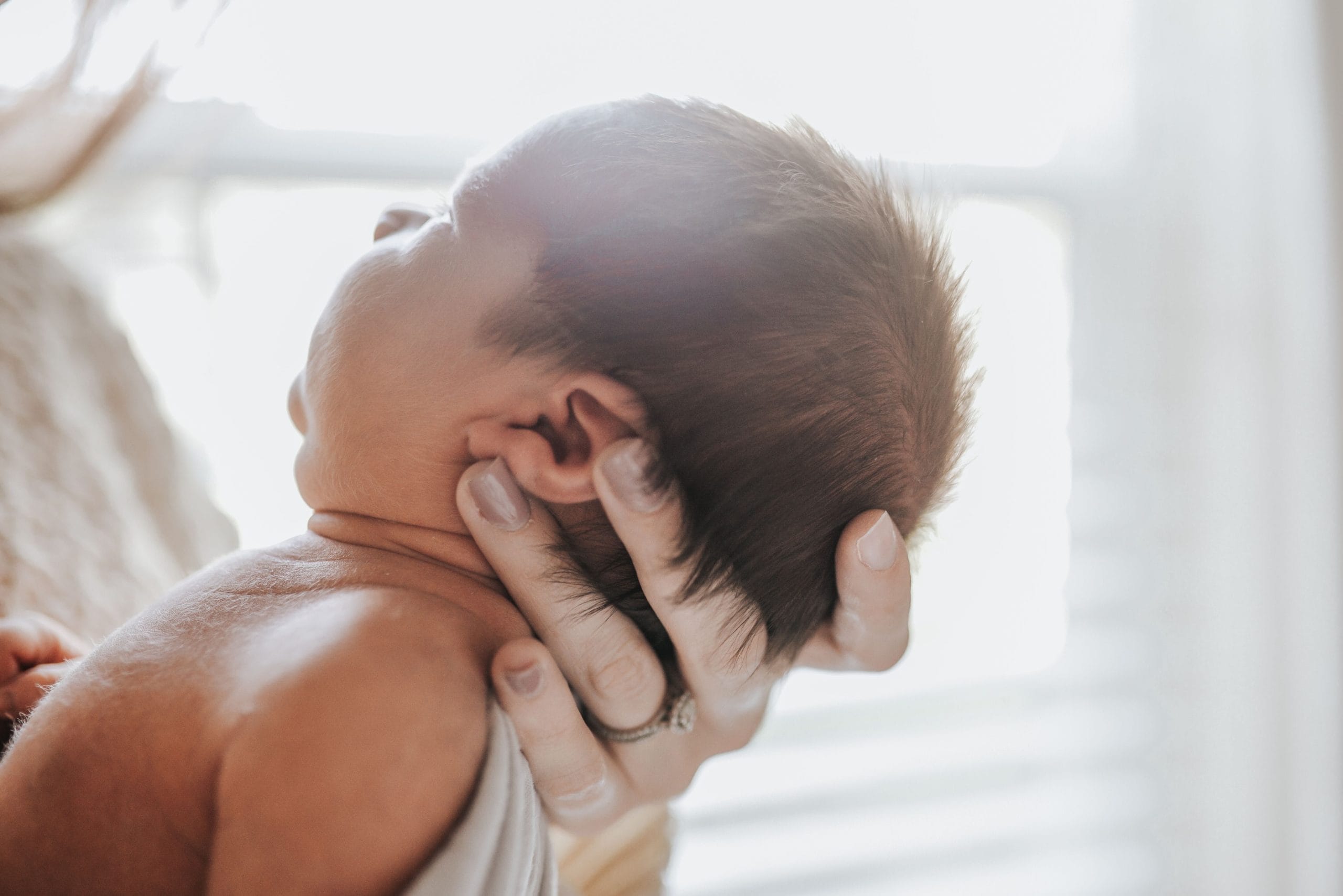 mom holding newborn baby in her palm