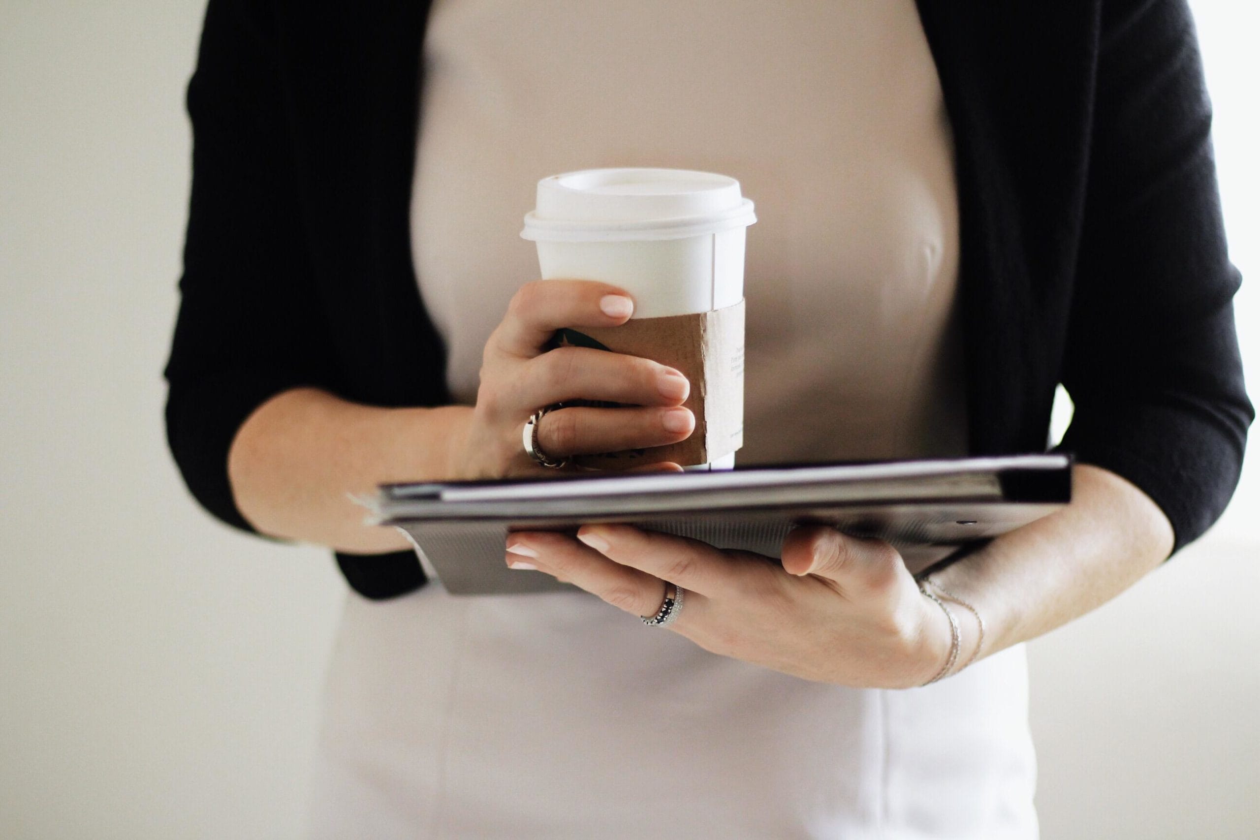 woman holding a cup of coffee and a tablet