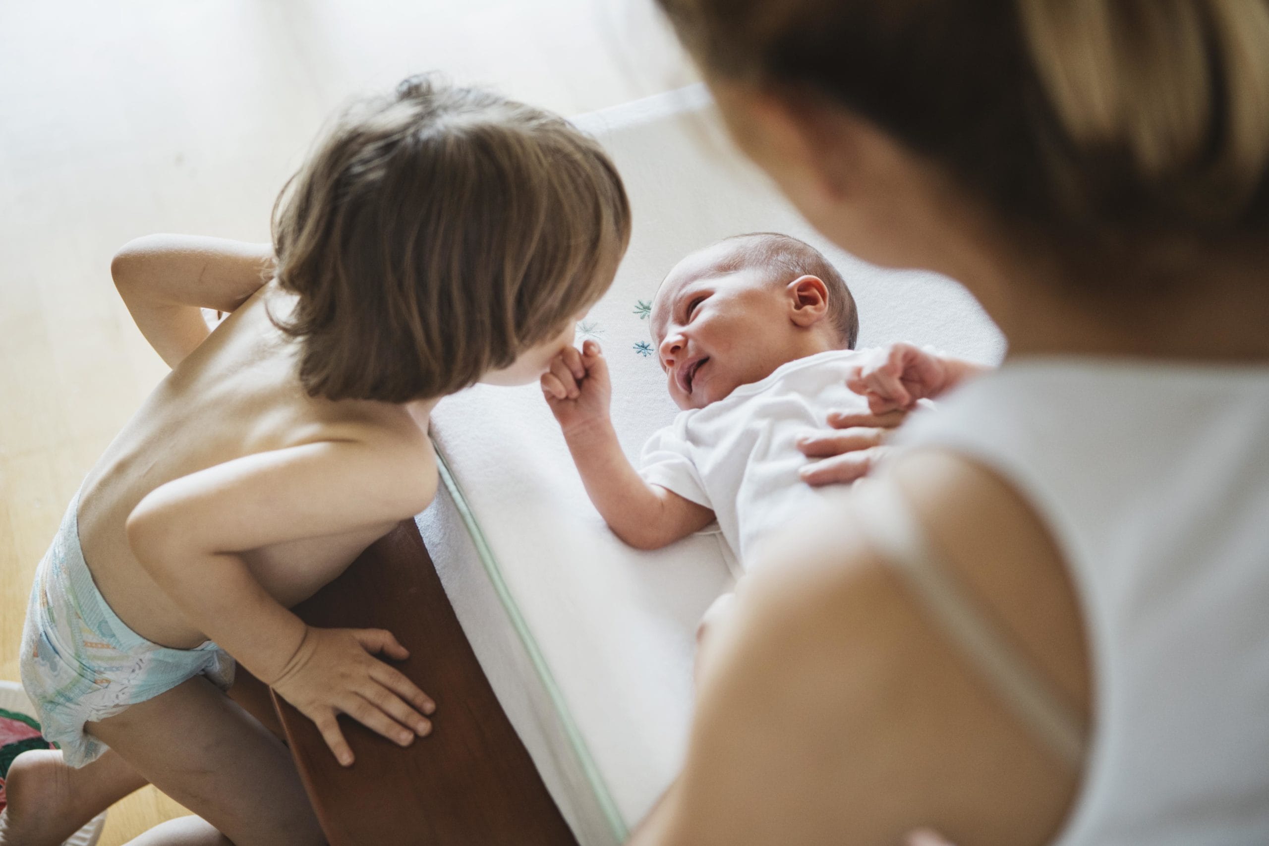 older sibling kissing new baby