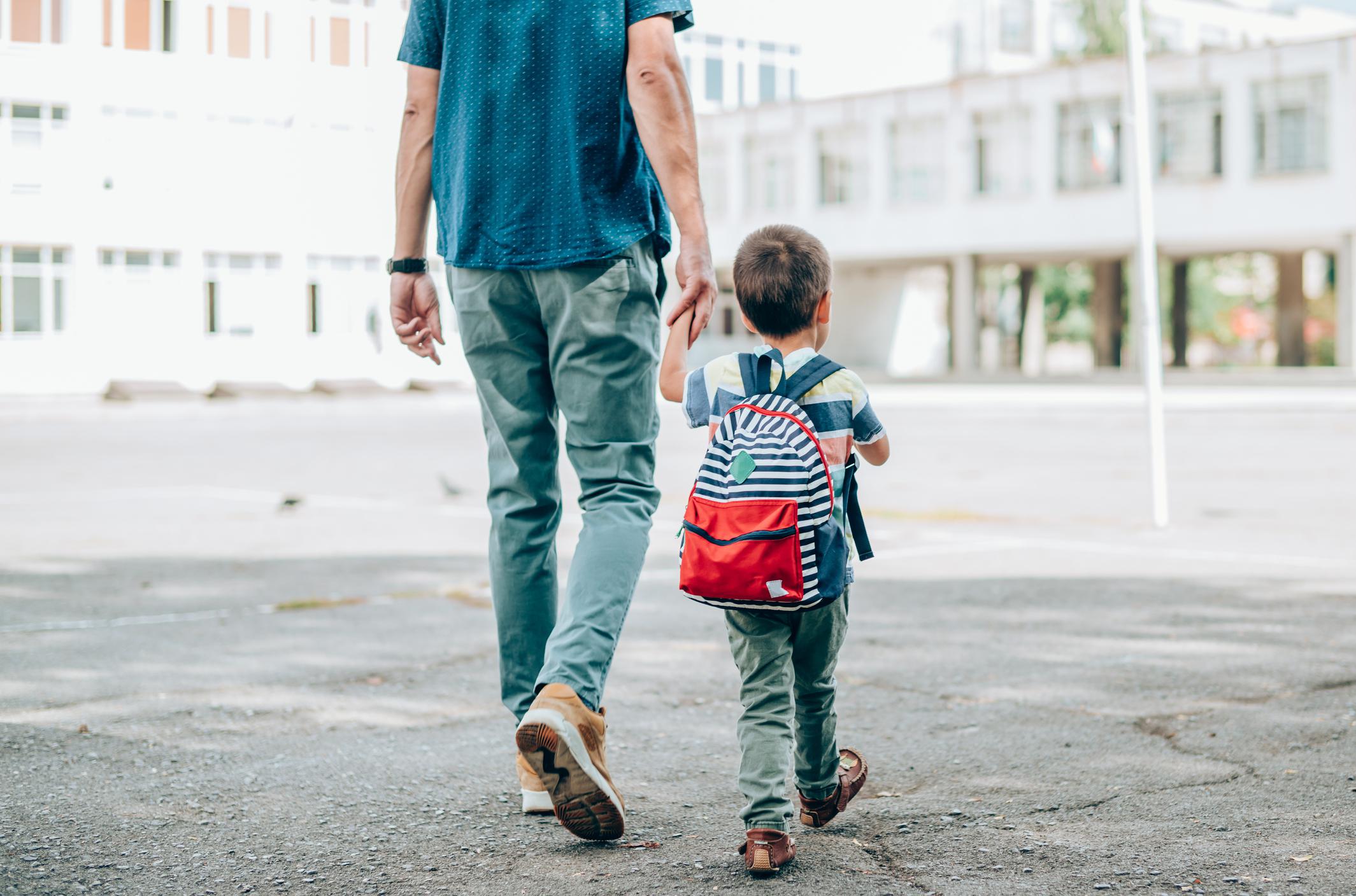 dad and son holding hands walking into school- encouraging phrases for kids