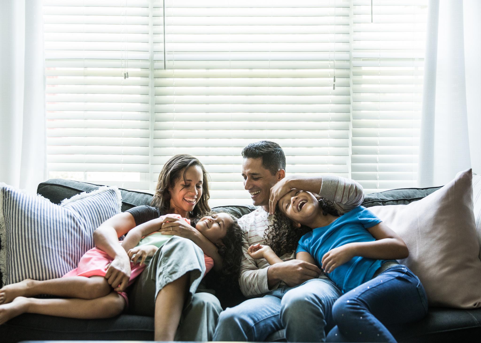 mom dad and two kids on couch- lazy parenting