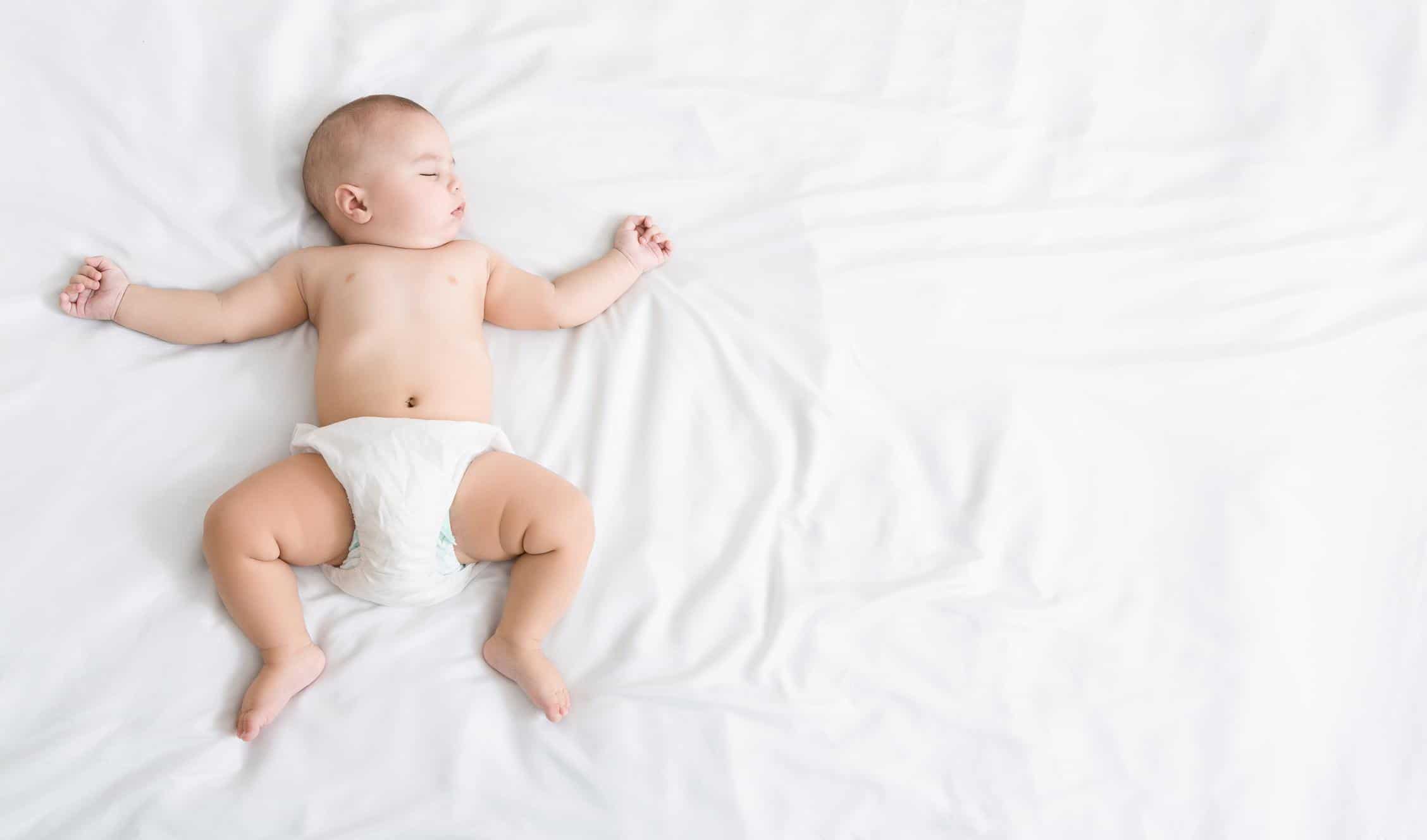 13-week-old baby sleeping on a bed